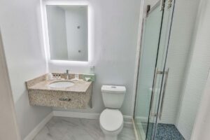 Modern bathroom with granite sink, glass shower, and blue tile floor like a luxury hotel spa.