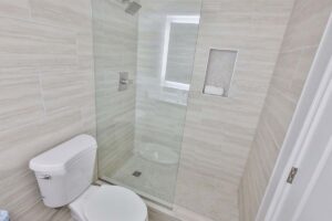 Modern bathroom with a glass-enclosed shower, evoking a Beachfront Resort's tranquil style.